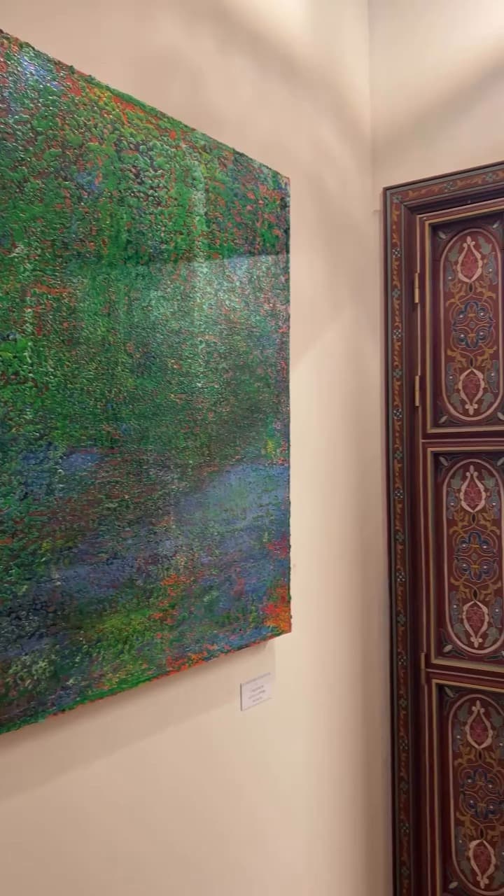 Large green abstract painting hung beside a painted Moroccan wooden door, Échappées belles exhibition