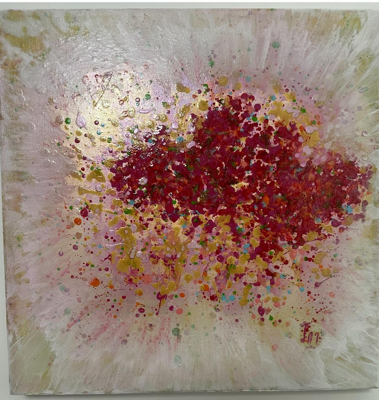 Abstract painting of a central cloud of crimson and gold splatter on a pale pink background with radiating strokes